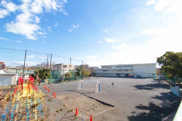 西寺尾小学校(線路沿いに建つ、各学年2クラス程の小学校。教育目標は「進んで学び　学びを深め　学びを活かす子ども」)